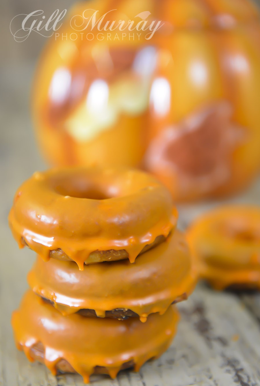 3 baked apple doughnuts dripping with Halloween icing
