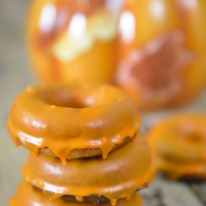 3 baked apple doughnuts dripping with Halloween icing