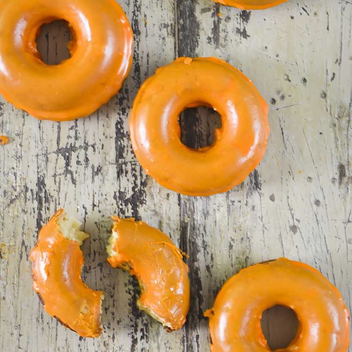 Irresistible baked apple doughnuts with orange coloured icing