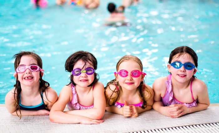 Swim and Skate - girls with goggles at the edge of the pool.