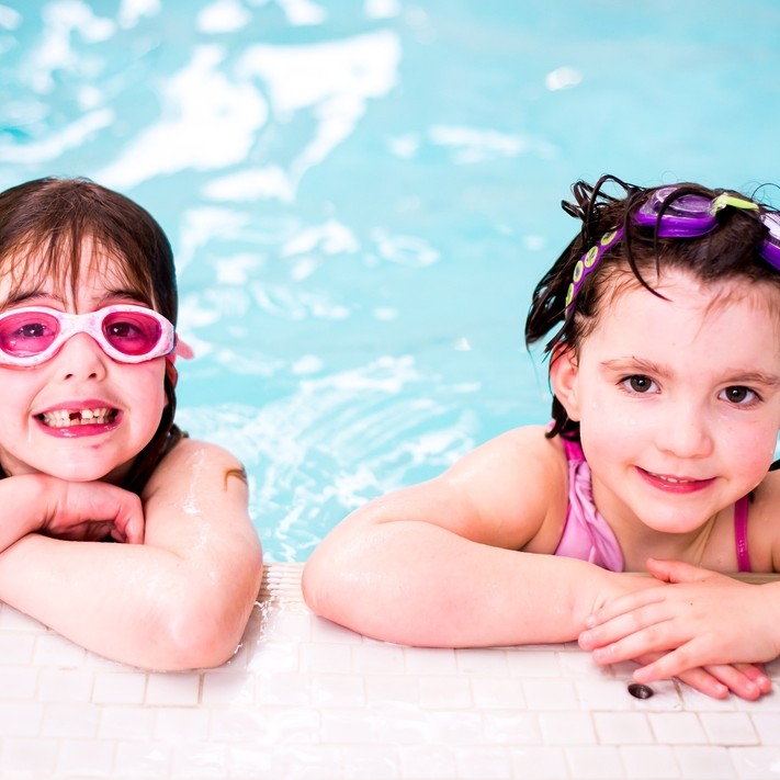 Young girls having a rest at side of the pool.
