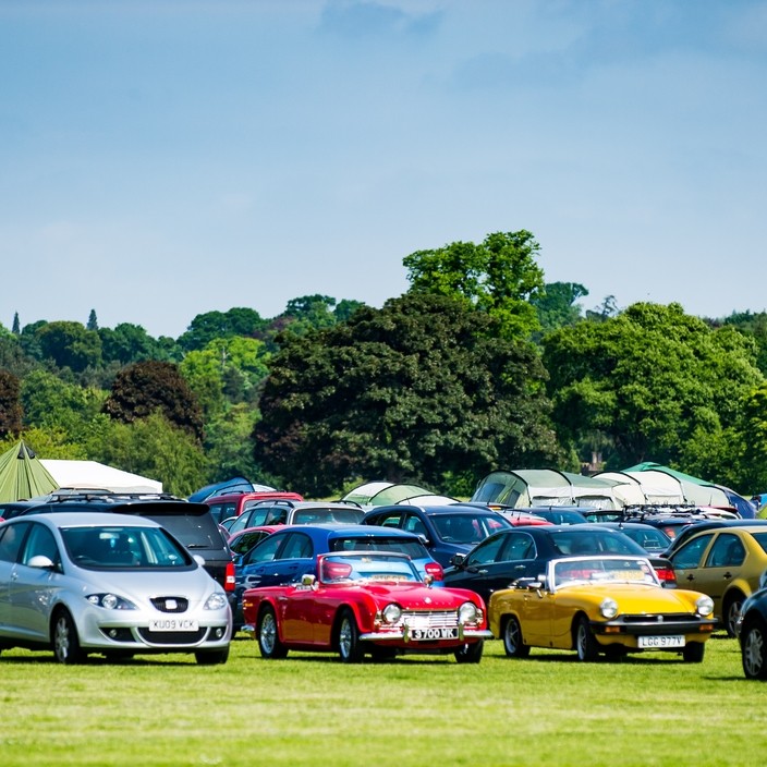 The cars in the car park for the Scottish Volleyball Championships at Perth in the North Inch, UK.  Those two classic cars look super!
