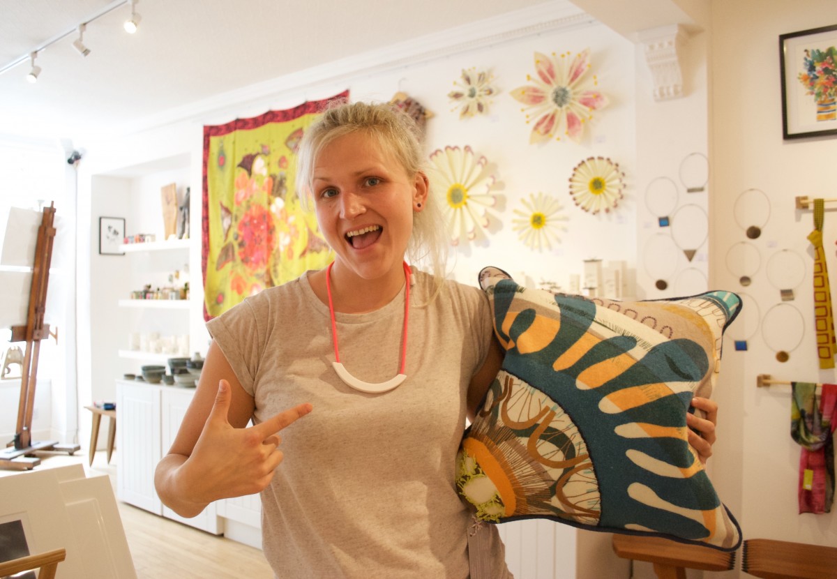 Tayberry Gallery in Perth UK is packed with the best of British, handmade art and design. Tayberry Gallery has been on Princes Street for 7 years, and showcases the work of lots of local creatives. Pictured is Louise (one half of Tayberry) loving the new cushions by Kelly Mackay inspired by Scottish geology, and Beth Lamont's colourful ceramic necklace!