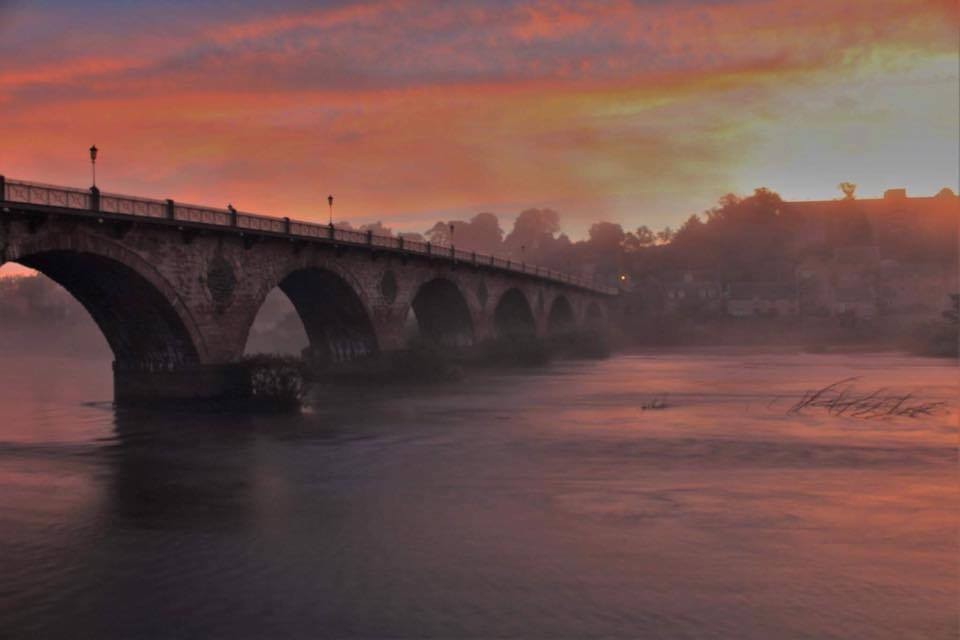 The Old Bridge with the warm orange glow of the sunset looks like something from a dream.