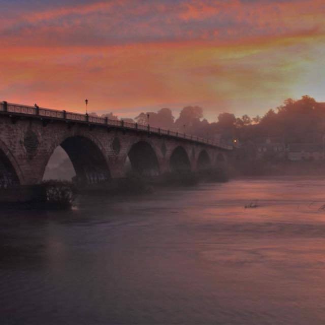The Old Bridge with the warm orange glow of the sunset looks like something from a dream.