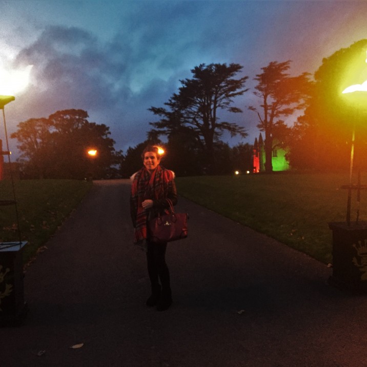 Aine standing at the fiery flambeaux at the entrance to the Scone Palace Twilight Illuminations.