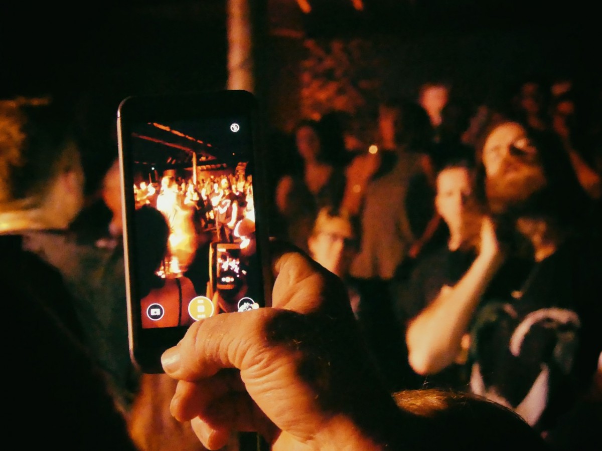 Man filming the crowd at Hunter and the bear on his phone.