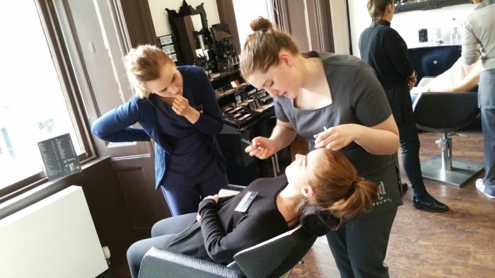 Abby threading a clients eyebrows.