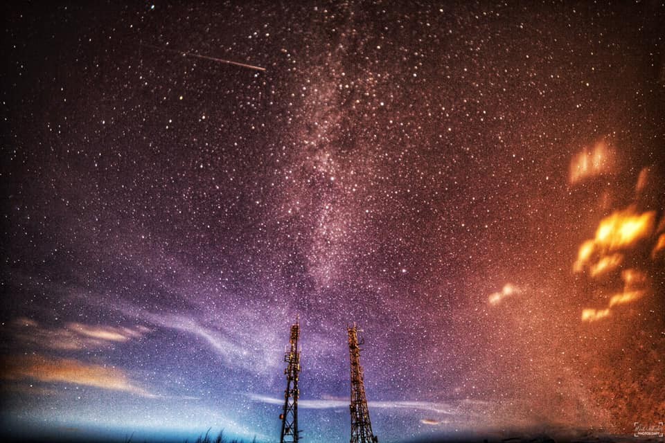 Hues of purple, azure, amber, and gold fleck and merge above a star studded sky at Mailer Hill.