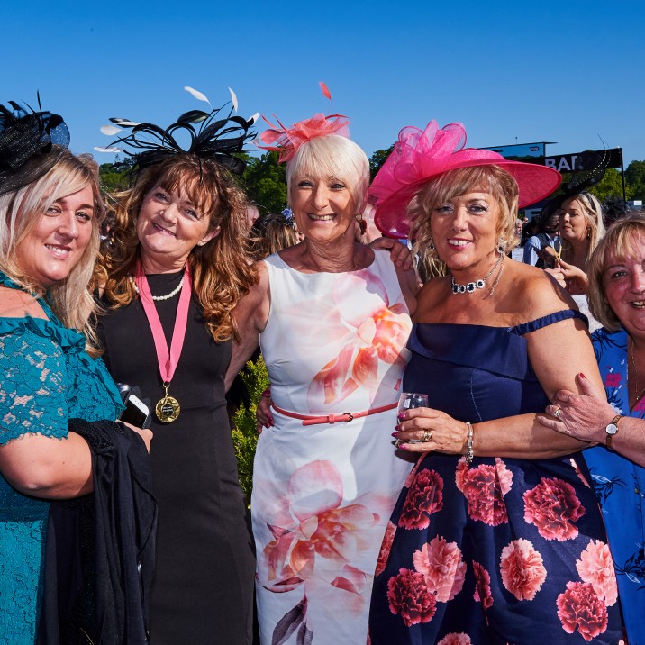 A group of friends with one sporting a nomination medal for Grand Lady!