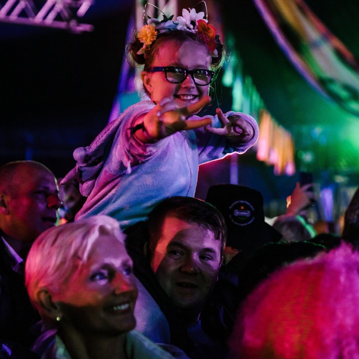 A young fan gets a kiddy back to see over the crowds at Rewind 2019.