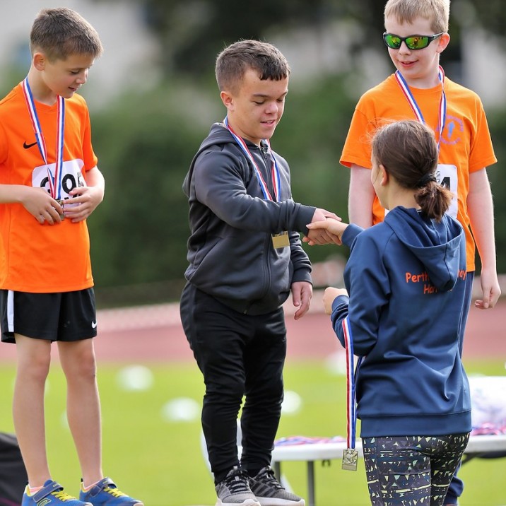 The Harriers Athlete Rep, Lauryn Wood, presenting medals to the next generation of young stars.
