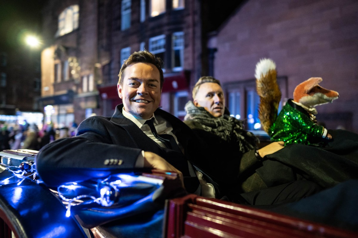 Stephen Mulhern and Basil Brush riding in style in a horse drawn carriage.