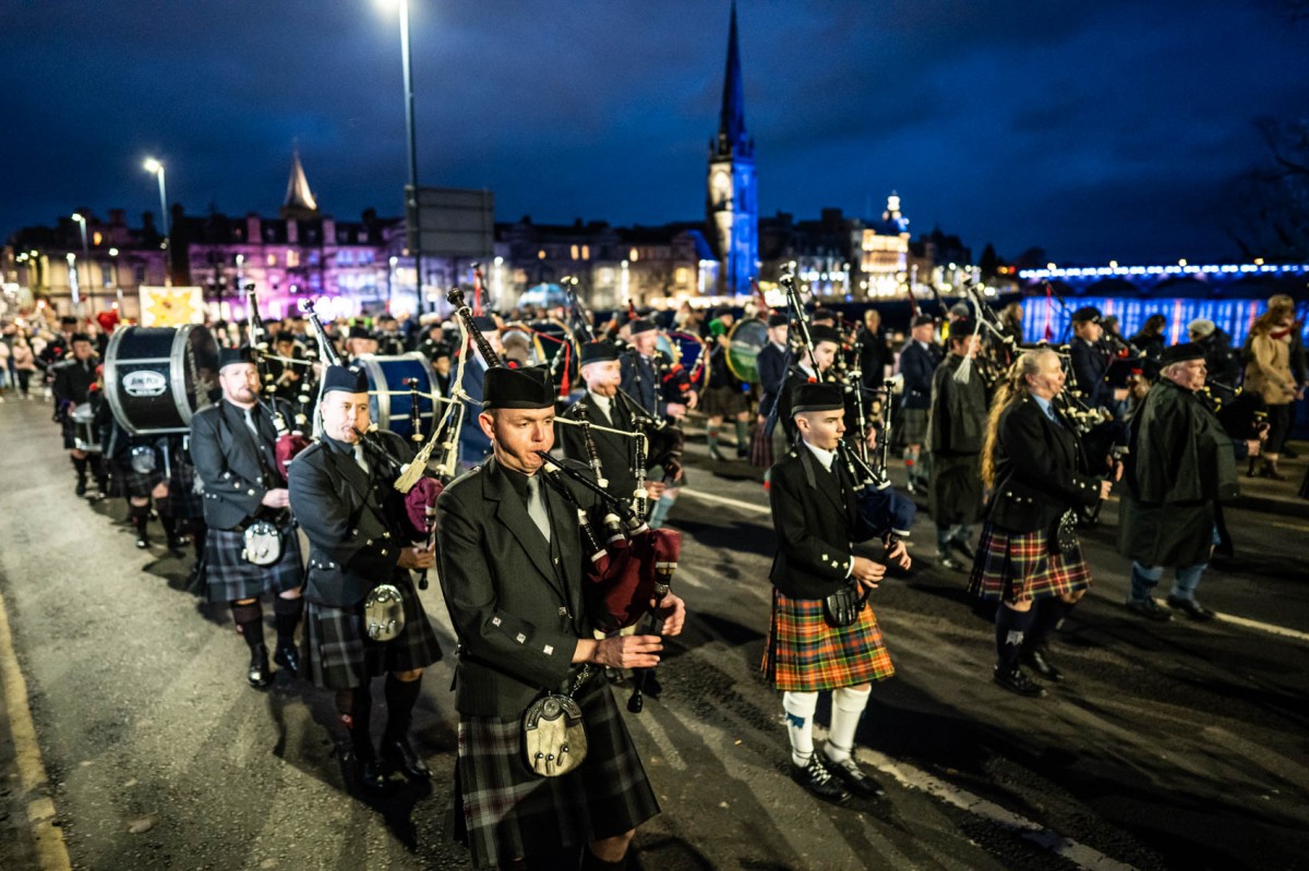 The pipe band march their way into Norrie Miller park.